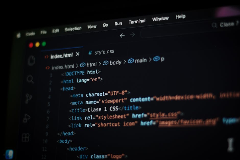 A close-up of a person's hand typing on a laptop keyboard with visible code displayed on the screen. The laptop is placed on a wooden surface, and the person's wristwatch is partially visible. The set